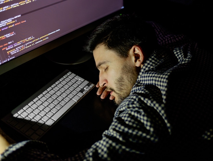 Foto programador autónomo cayendo boca abajo tomando una siesta con la computadora. concepto de cansado y vago