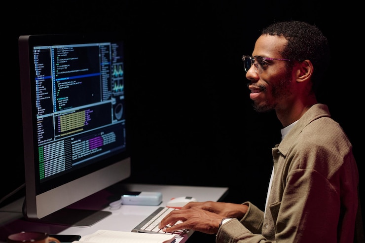 Foto programador enfocado analizando el código en la pantalla de la computadora