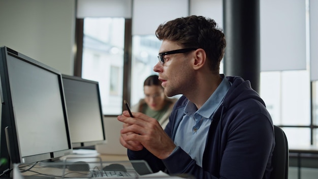 Programador enfocado comprobando el código en el escritorio. Hombre profesional resolviendo problemas.