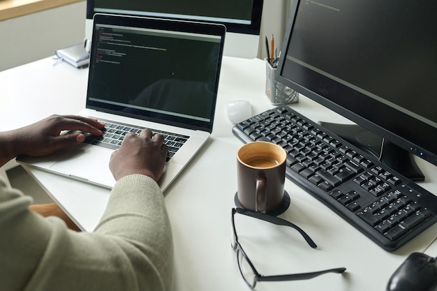 Programador escribiendo códigos en una laptop