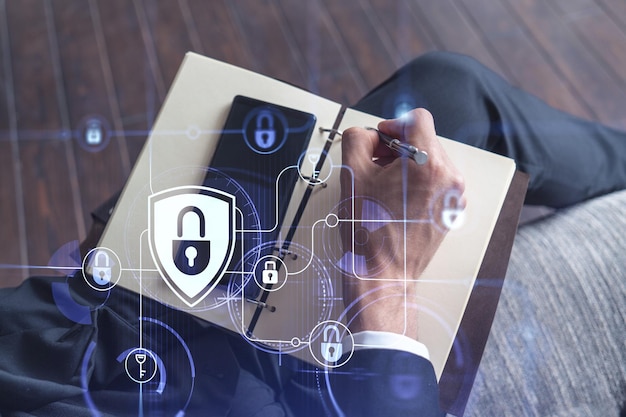 El programador está tomando notas de las necesidades de los clientes para proteger la seguridad cibernética de los ataques de piratas informáticos y guardar los datos confidenciales de los clientes. Uso de teléfonos inteligentes Iconos de hologramas de candados Ropa formal