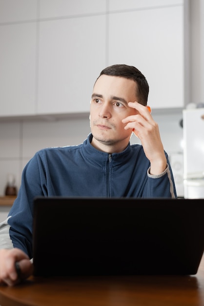 Foto programador freelancer trabalhando em casa na cozinha e usando laptop