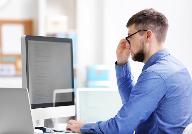 Programador joven guapo que trabaja en la oficina