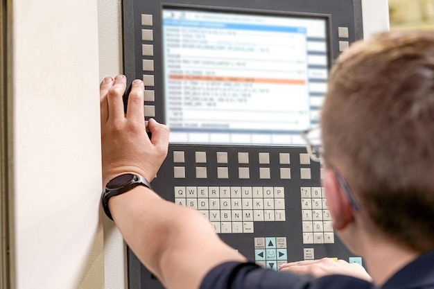El programador de la máquina de fresado CNC hace ajustes en el programa para cambiar los parámetros de corte