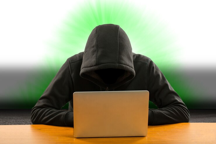 Foto programador de piratas informáticos que utiliza una computadora portátil para piratear información y datos de la cuenta de usuario.