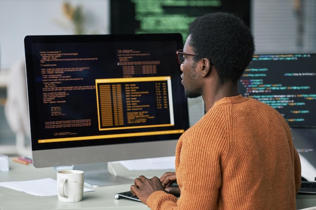 Programador que encuentra y soluciona problemas en el código en la pantalla de la computadora