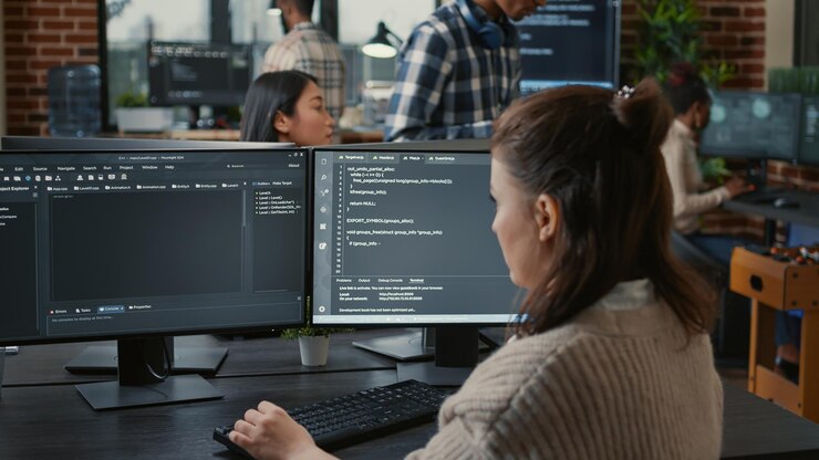 Foto programador de software escribiendo código frente a múltiples pantallas de computadora que muestran un algoritmo de inteligencia artificial. base de datos de codificación de desarrolladores mientras sus colegas realizan computación en la nube en línea.
