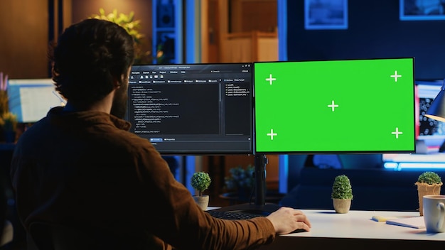 Programador de software escribiendo líneas de código en la computadora de chroma key en casa