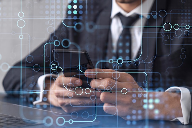 Programador sosteniendo en las manos un teléfono inteligente y probando una aplicación innovadora para brindar un servicio completamente nuevo Primer plano Gráficos tecnológicos de holograma Concepto de equipo de desarrollo Ropa formal