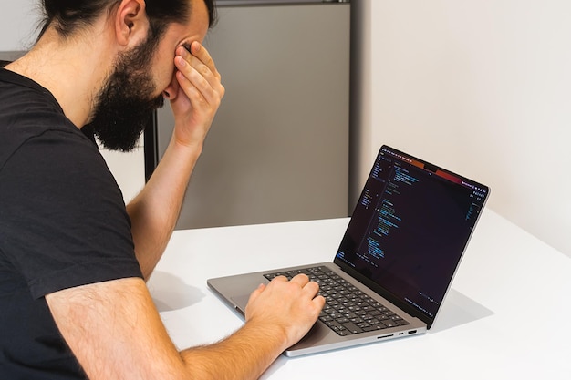 Un programador trabaja remotamente en casa en su portátil