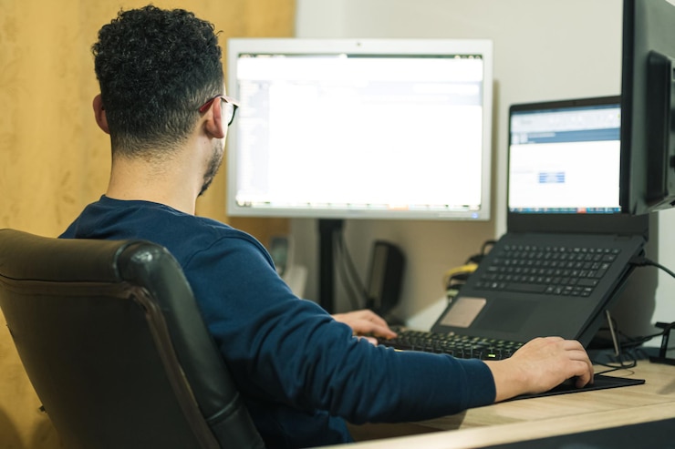Foto programador trabajando remotamente desde casa y desarrollando páginas web por la noche.