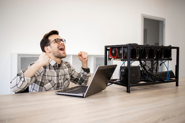 Programador trabajando en su plataforma de minería de criptomonedas comprobando el valor y las ganancias de bitcoin