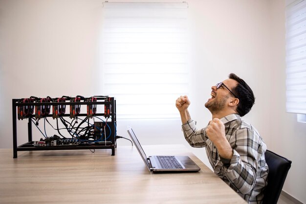 Programador trabajando en su plataforma de minería de criptomonedas comprobando el valor y las ganancias de bitcoin