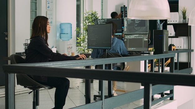 La programadora asiática se centró en escribir código en la oficina de desarrollo de software, utilizando grandes datos de seguridad en la ventana del terminal. Desarrollador de bases de datos que se concentra en la creación de algoritmos para la agencia de TI.