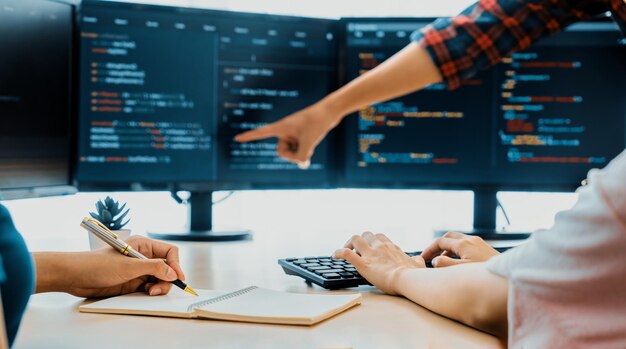 Programadora tomando una nota mientras el desarrollador web presenta el programa Burgeoning