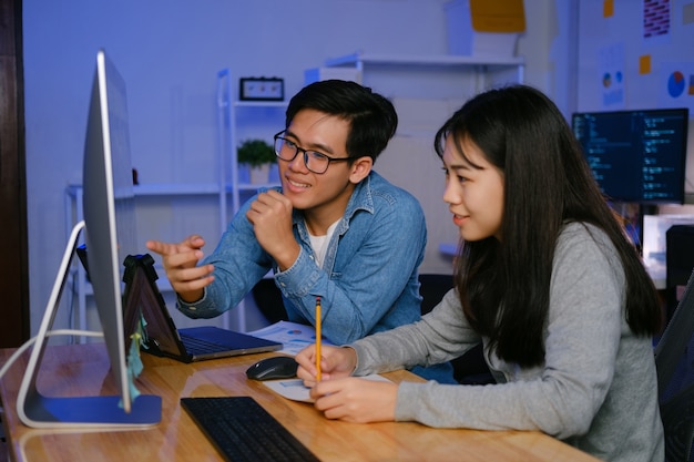 Programmierer und Entwickler arbeiten nachts in einer Softwareentwicklung und Codierungstechnologien zusammen.