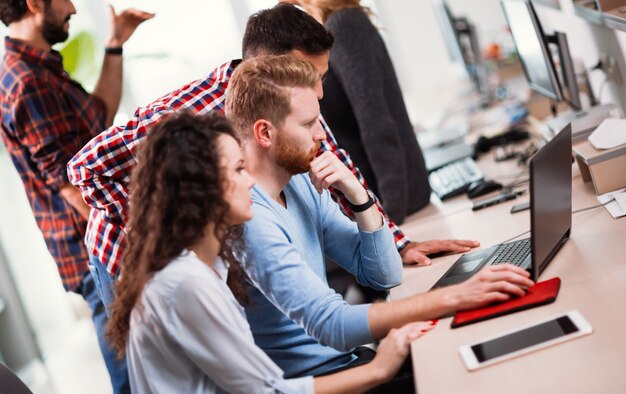 Foto programmierer und geschäftsleute, die im firmenbüro zusammenarbeiten