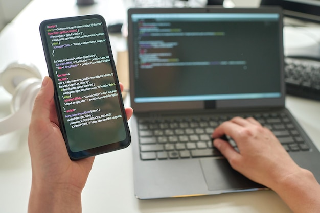 Programmierer verbindet Smartphone mit Laptop
