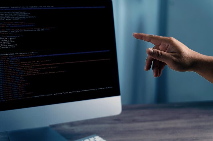 Foto programming code on representing person pointing computer screen displaying code indicating programming or software development activity