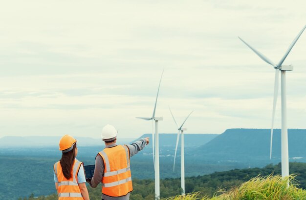 Progressives Konzept von Ingenieuren, die im Windpark auf dem Berg arbeiten