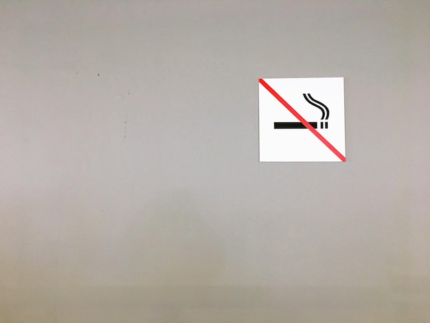Foto se prohíbe fumar en la pared gris.
