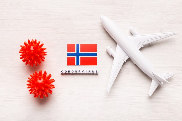 Prohibición de vuelos y fronteras cerradas para turistas y viajeros con coronavirus covid-19. Avión y la bandera de Noruega sobre un fondo blanco. Pandemia de coronavirus.