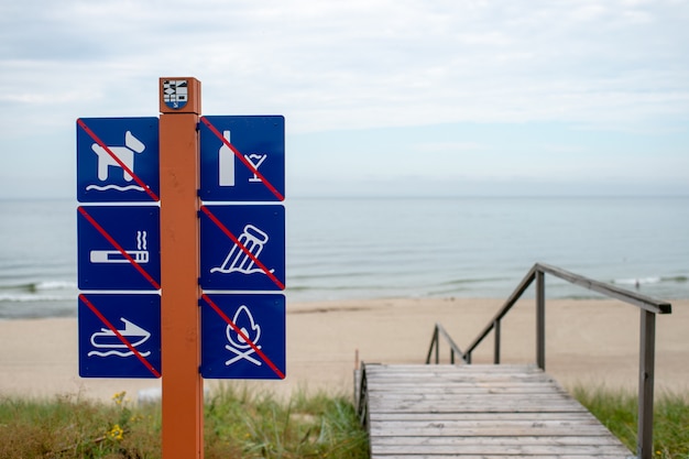 Foto proibindo sinais na praia contra o mar perto de escadas