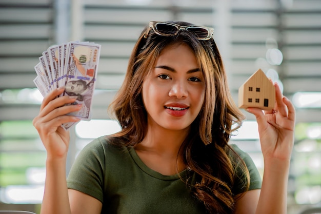 Projekthäuser Barkredit und Wohnheime Junge Frau mit einem Modellhaus aus Holz