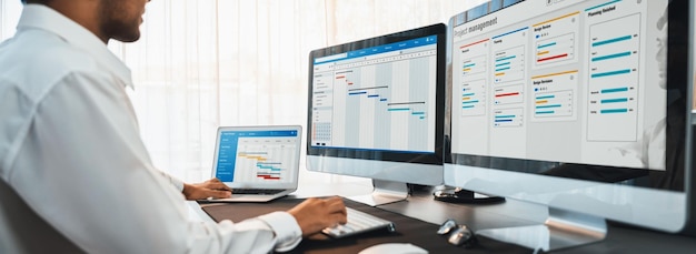 Projektmanager plant Zeitpläne für Geschäftsaufgaben im Büro mithilfe der Anzeige von Gantt-Diagramm-Software auf dem Bildschirm. Moderne Unternehmensführung und Arbeitsablauforganisation bahnbrechend