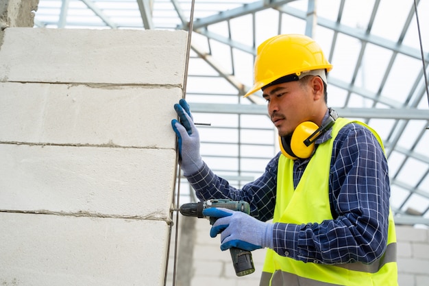 Projete usando uma máquina de broca mecânica no canteiro de obras, conceitos de construção.