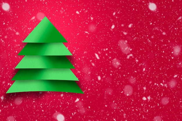 Projeto da árvore de Natal verde com textura de papel e fundo nevado. Conceito de Natal.