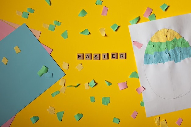 Projeto de arte infantil artesanato para crianças Ovo de Páscoa feito de papel Papel colorido por todo o lado inscrição Páscoa