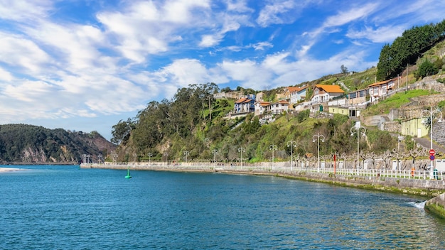 Promenade mit malerischen Laternenpfählen und bunten Häusern am Meer im Dorf Ribadesella Asturias