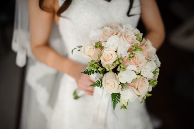 Prometida en un hermoso vestido blanco con un ramo