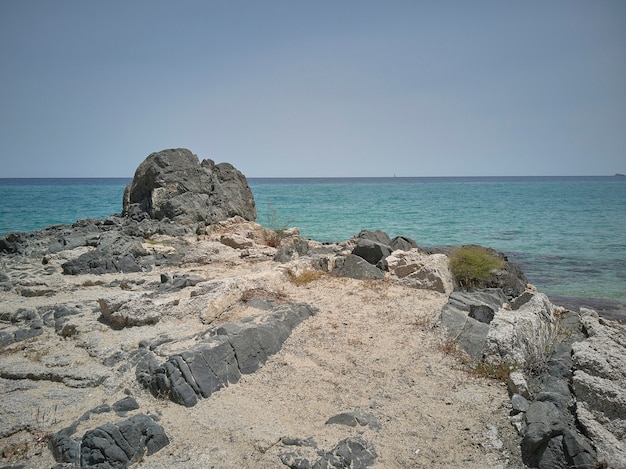 Promontorio rocoso con vistas al agua azul del mar en un paraje natural e incontaminado.