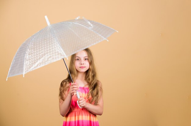 Pronóstico del tiempo Temporada de otoño Disfruta del concepto de lluvia Accesorio impermeable Vienen días de lluvia Me encantan los días de lluvia Niña feliz sostiene un paraguas transparente Disfruta del clima lluvioso Protección invisible