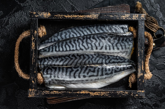 Pronto para cozinhar peixe de filé de cavala cru fatiado em uma caixa de madeira com ervas Fundo preto Vista superior