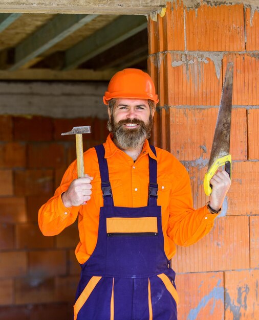 Pronto para desafios. O artesão mantém a cabeça segura no capacete. Melhoria e renovação. Construtor de homem brutal. Construtor de engenheiro de uniforme. Capacete de construção de homem. Oficina de faz-tudo. Criatividade e prática.