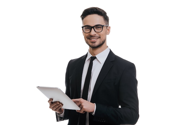 Pronto para lhe dar conselhos. Jovem bonito com terno completo segurando um tablet digital e sorrindo