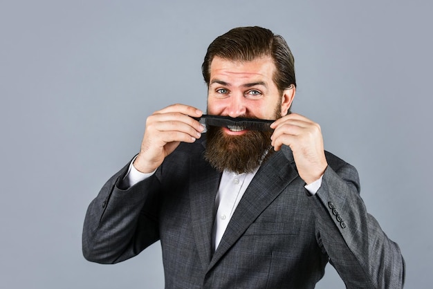 Foto pronto para o barbear matinal cuidados com o barbeiro masculino homem barbudo segura a escova de cabelo cuidados com o cabelo e a barba cuidado facial do homem brutal e confiante hipster maduro com barba hipster caucasiano brutal