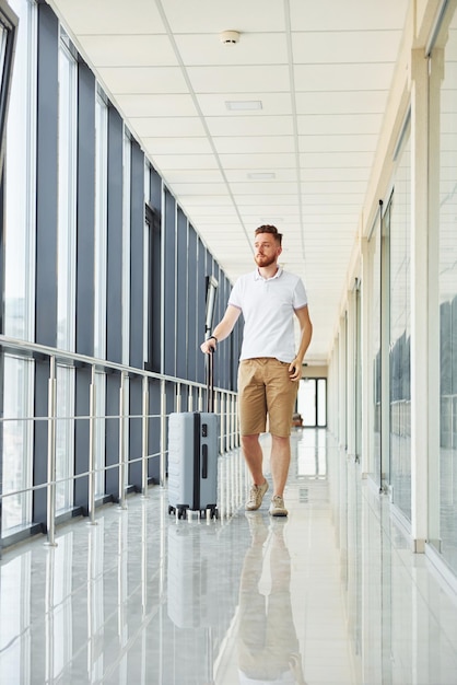 Pronto para o voo jovem viajante está no hall de entrada do aeroporto