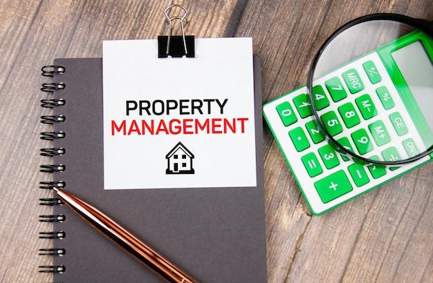 Property Management Textkonzept auf Tisch mit Taschenrechner und HaussymbolReal Estate Management