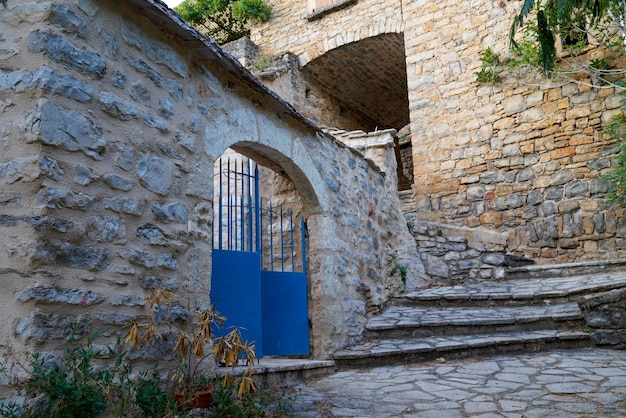 Propiedad de acceso de puerta de casa de piedra de arco de metal vintage de acero azul clásico metálico en ciudad medieval