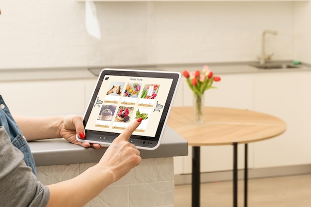 La propietaria de Delicatessen con tableta digital con máscara facial preparando el pedido de comestibles en línea.