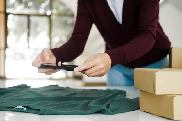 Propietario femenino tomando fotografías del producto en línea