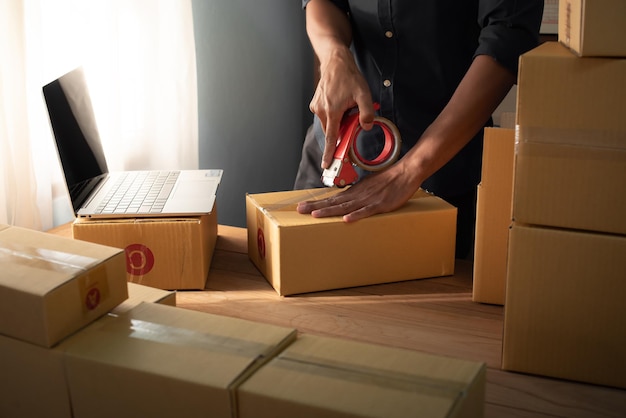 propietario de un negocio masculino que trabaja empacando el pedido para enviarlo al cliente