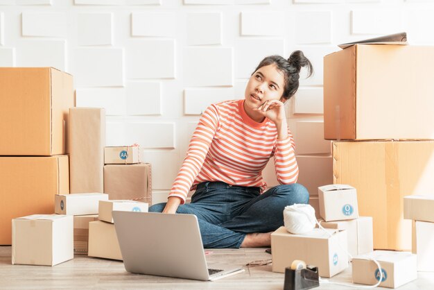 Propietario de negocio de mujeres asiáticas trabajando en casa con caja de embalaje en el lugar de trabajo