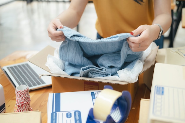 Propietario de una pequeña empresa en línea. Joven emprendedor emprendedor en línea propietario de una pequeña empresa que trabaja en casa, embalaje y situación de entrega