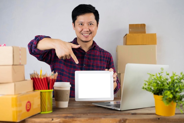 El propietario de una pyme de pequeñas empresas de nueva creación utiliza una tableta de pantalla blanca en blanco