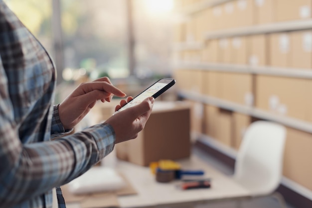 Propietario de una tienda de comercio electrónico que utiliza un teléfono inteligente
